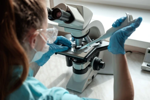 Technicienne de laboratoire observant un échantillon au microscope